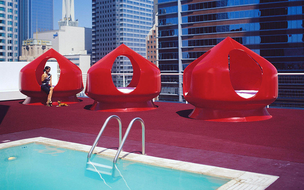 woman on rooftop in red chair by pool – The Standard – point one percent