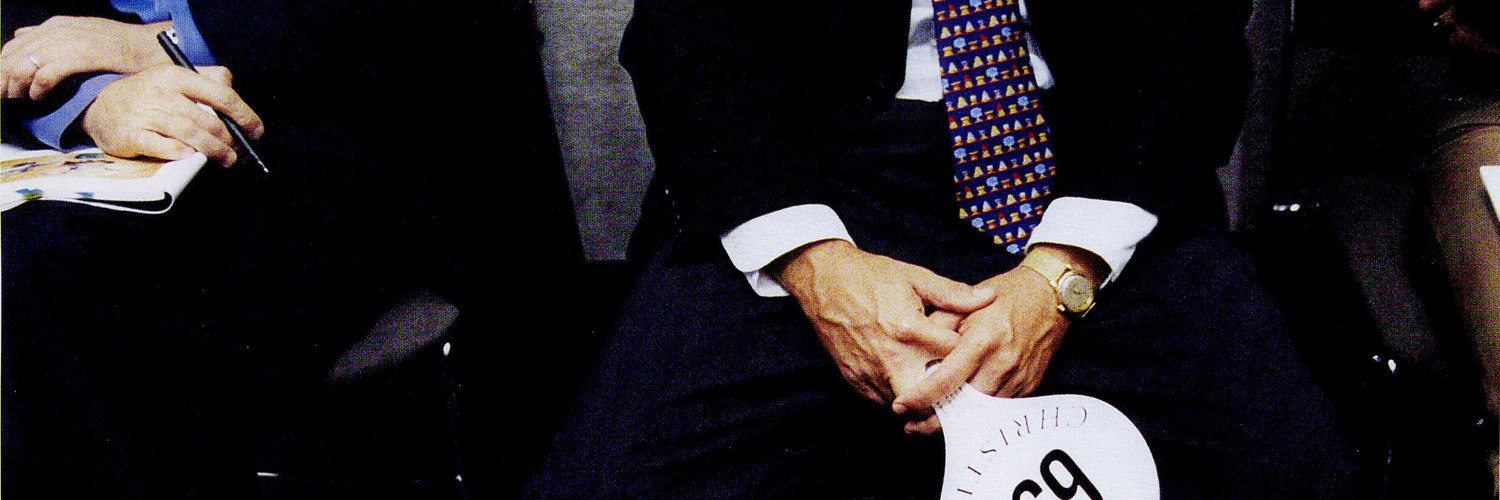 man in suit with auction paddle – Christie’s – Point One Percent